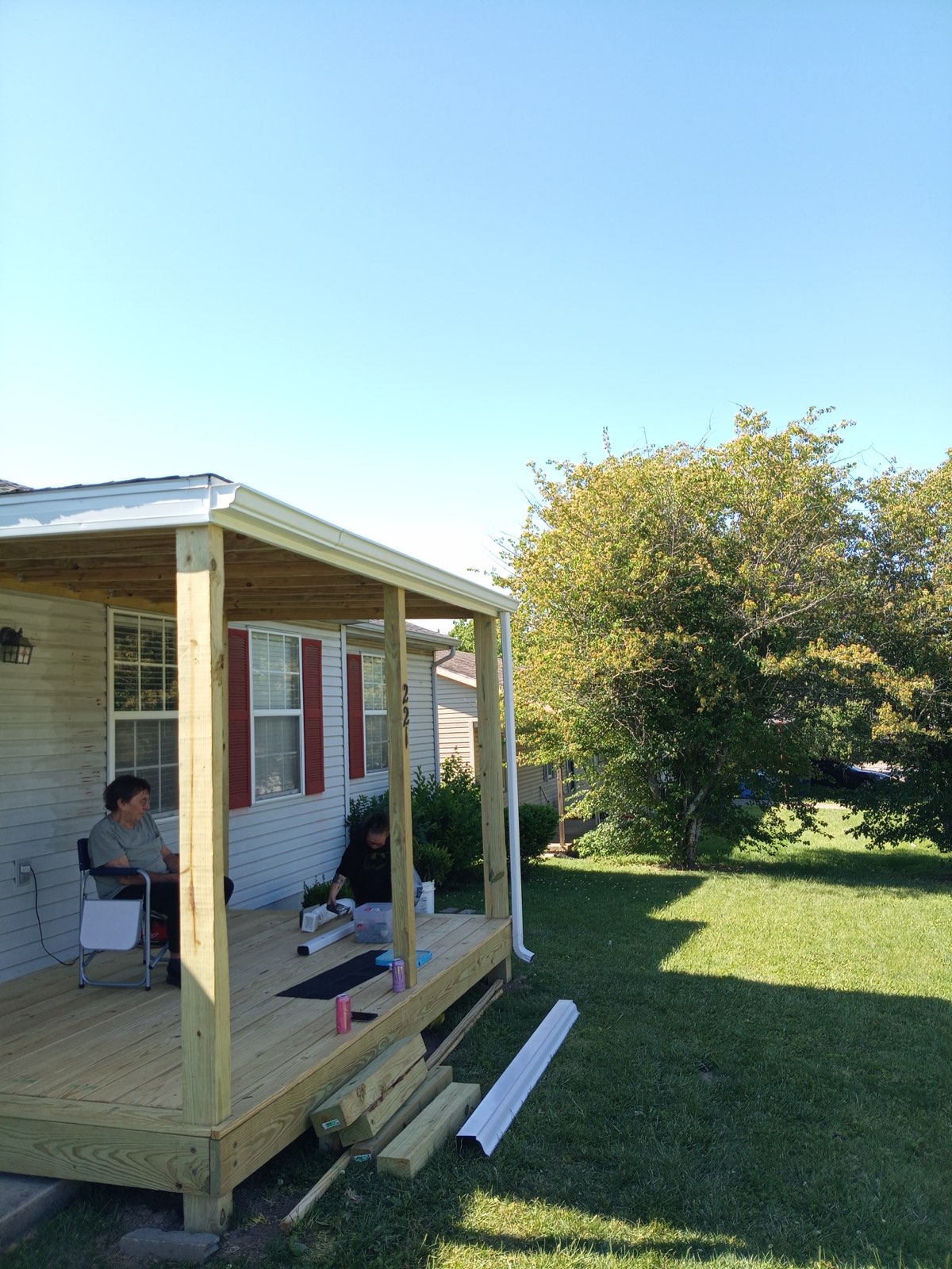 Finished covered porch with new decking, posts and roof, in use by the homeowners