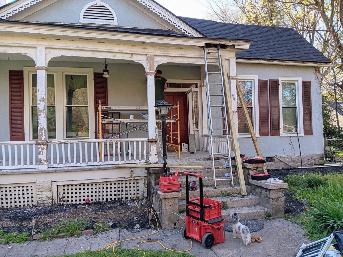 Historic Danville home during restoration with scaffolding set at the porch and original trim being repaired