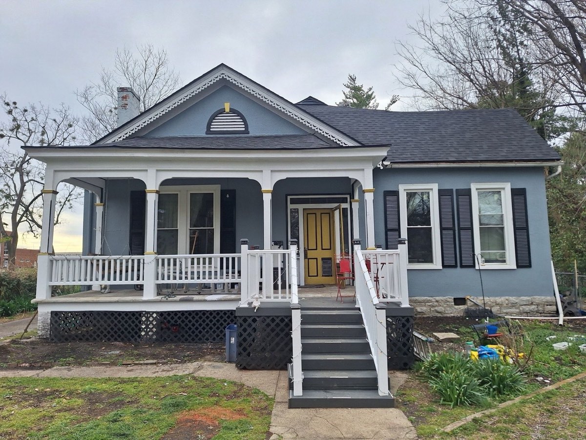 Restored historic Danville home with a new roof, fresh blue and white exterior paint, and rebuilt porch railings