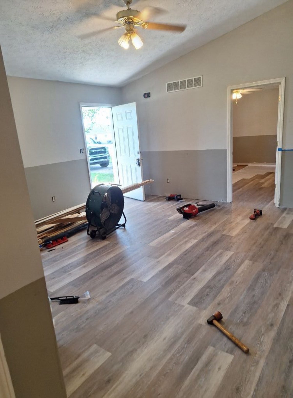 Interior of a Danville home mid-renovation with new wood flooring going down and fresh paint on the walls
